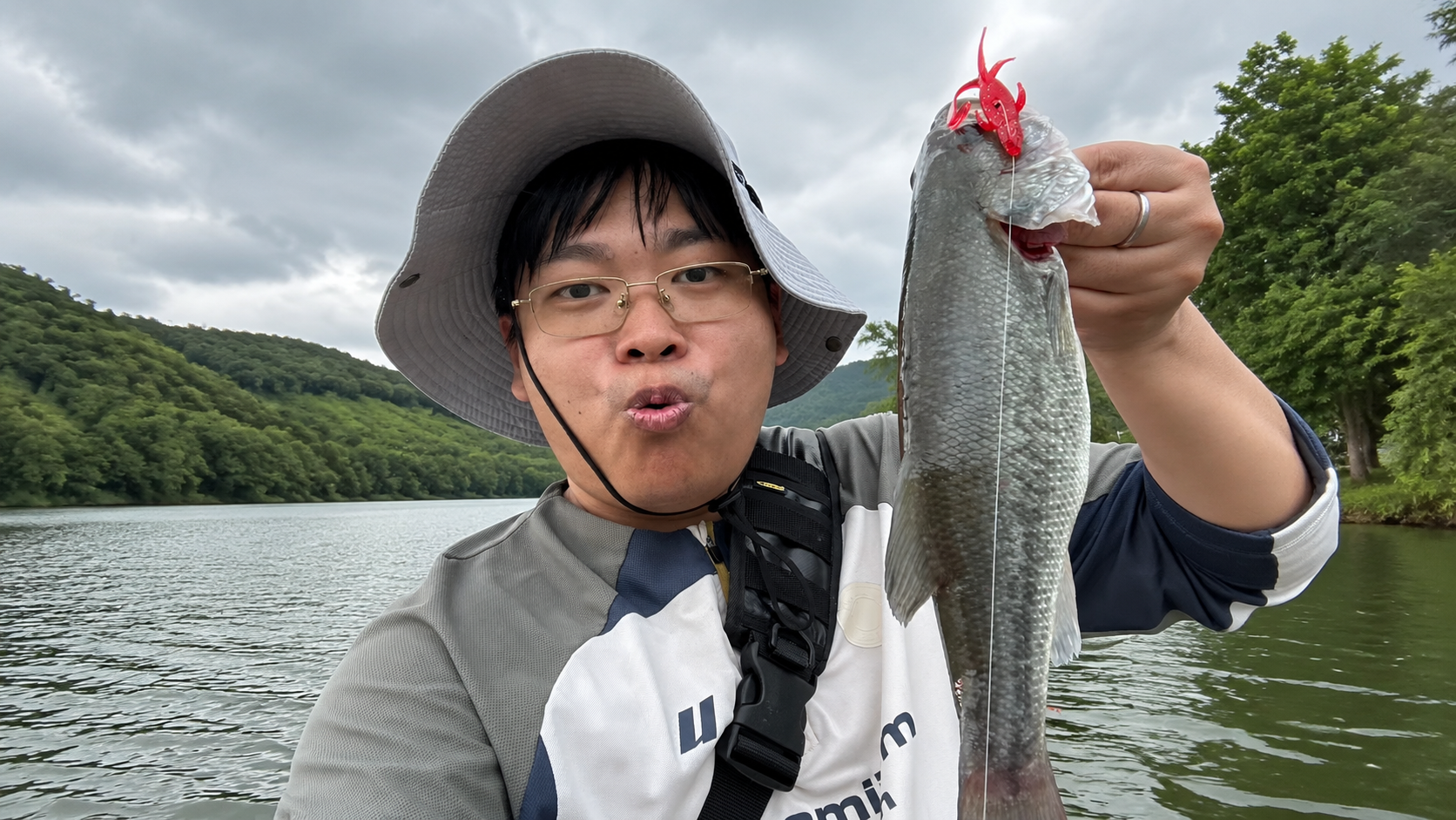 Chester holding a fish by the water