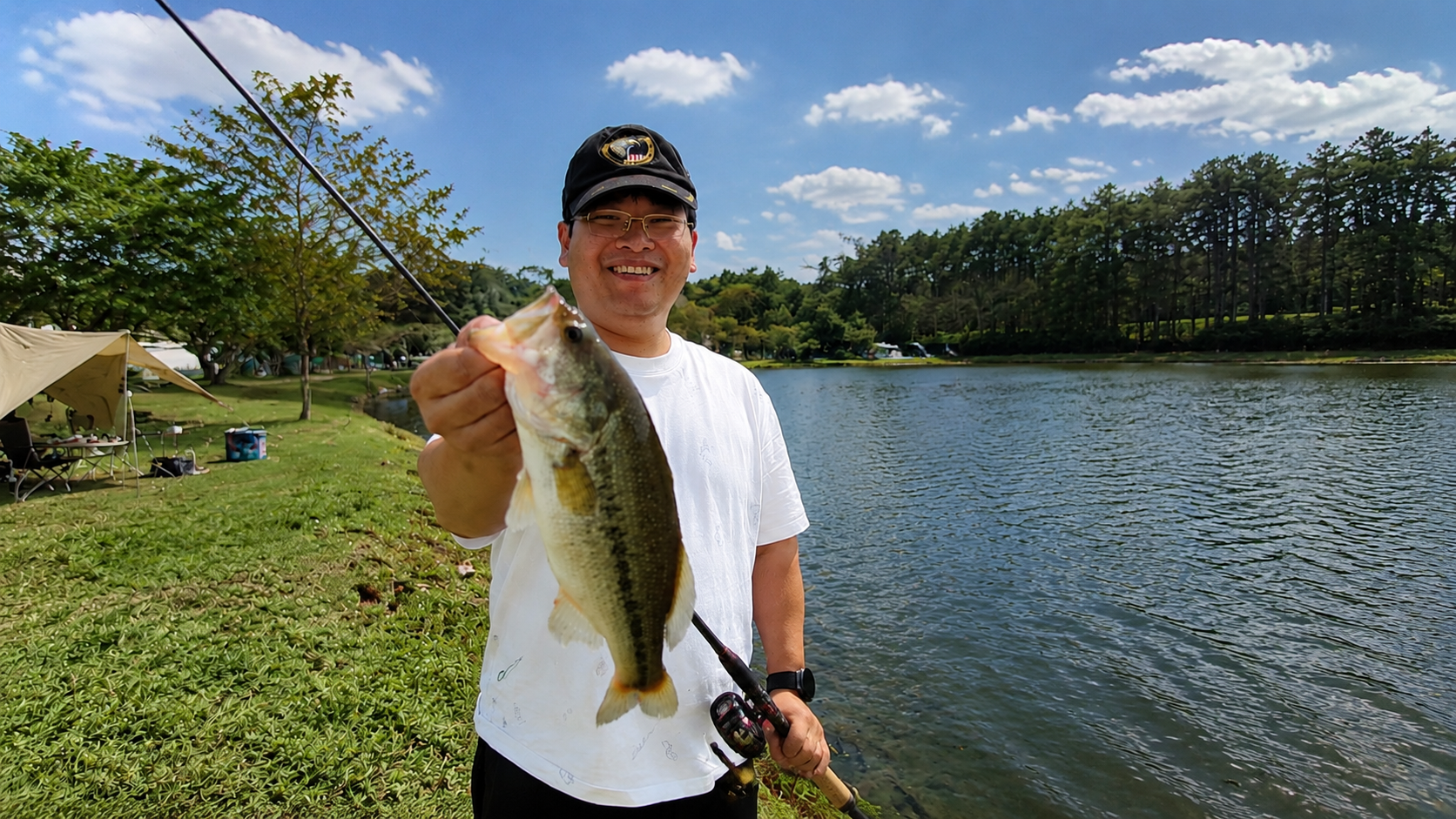 Chester holding a fish beside the lake